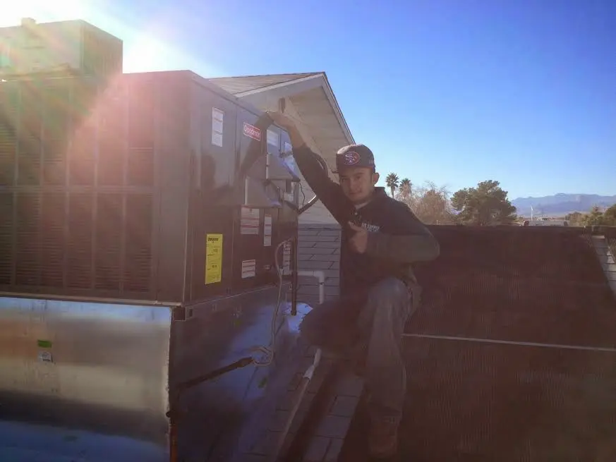HVAC technician performing AC Tune-Up on a rooftop unit in Miramar Beach
